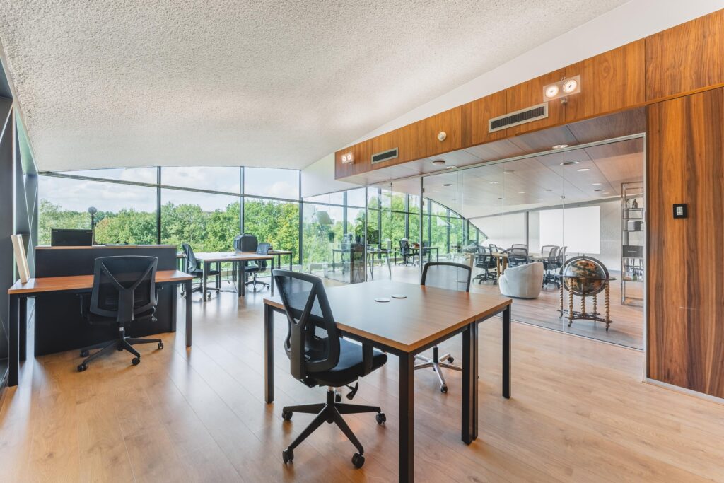 Modern kantoorinterieur aan de Prof. W.H. Keesomlaan met glazen wanden, houten details en uitzicht op groen.